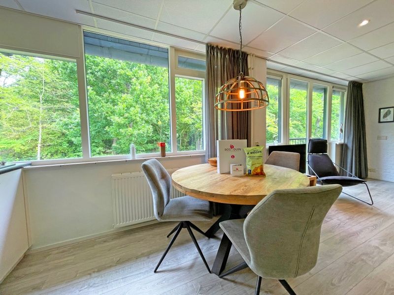 Runder Esstisch an grossen Fenstern im Apartment Bos en Duin 23, De Dennen, Texel.