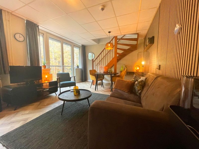 Geraeumiges Wohnzimmer im Appartement Bos en Duin 24, Texel mit Blick auf die Natur von De Dennen, ideal zum Entspannen.