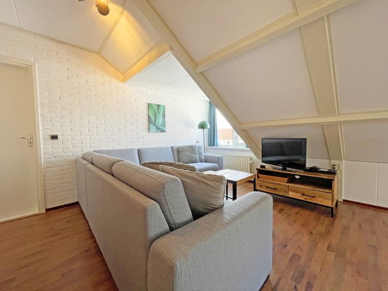 Comfortable sitting area with television in Apartment Bos en Duin 33, De Dennen, Texel for relaxing evenings.