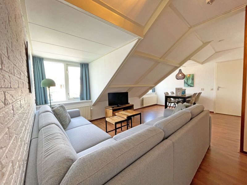 Spacious living room with large windows in Apartment Bos en Duin 33, De Dennen, Texel offers views of the surroundings.