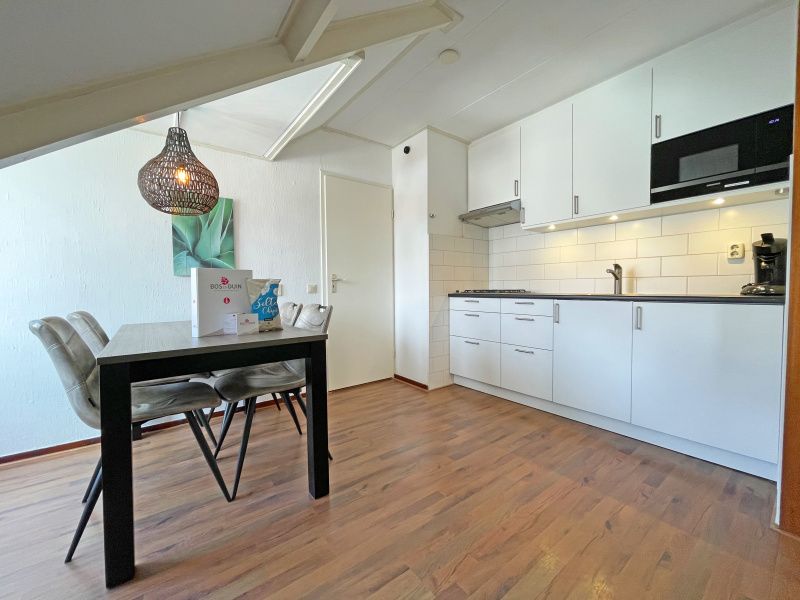 Kitchen and dining area in Apartment Bos en Duin 33, De Dennen, Texel with clean lines and modern facilities.
