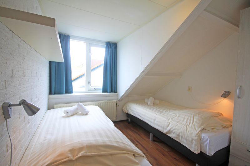 Second bedroom in Apartment Bos en Duin 33, De Dennen, Texel with cozy decor and lots of natural light.