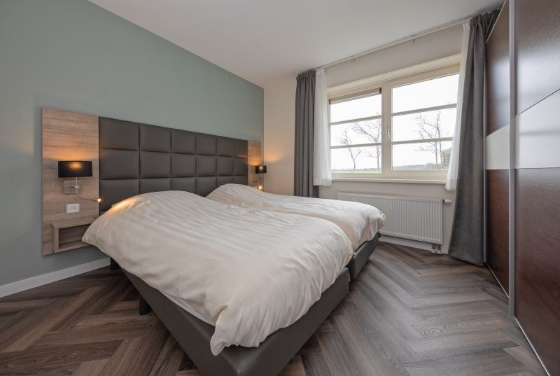 Wellness badkamer in Appartement Bos en Duin 37, De Dennen, Texel met ligbad en elegant design.