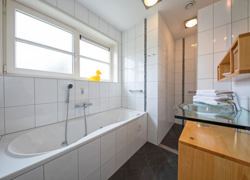 Buitenzijde van Appartement Bos en Duin 37, De Dennen, Texel met charmante architectuur en tuin.