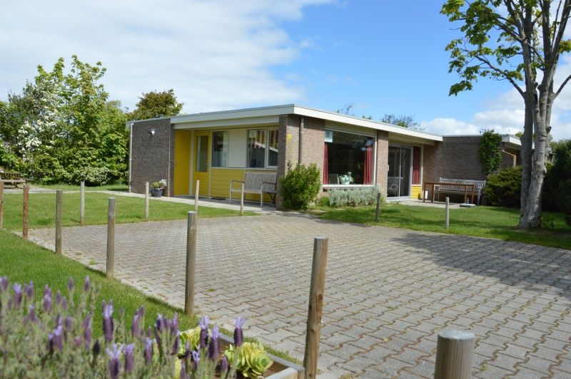 Bungalow Verste Coogh 62 in De Dennen, Texel mit bluehendem Lavendel und sonnigem Garten.