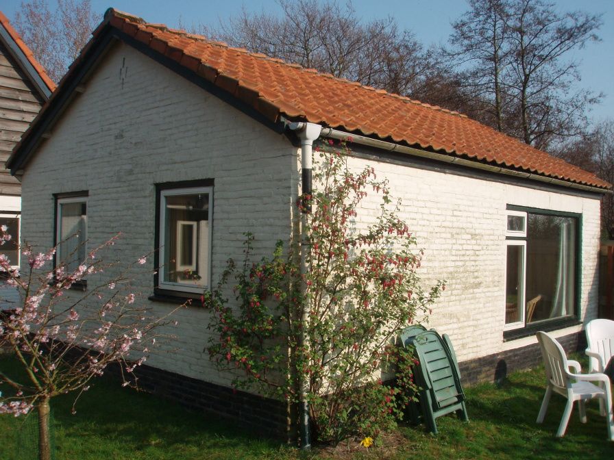 Duenenhaus in De Dennen, Texel, mit schoenem Garten und klassischer Backsteinfassade.