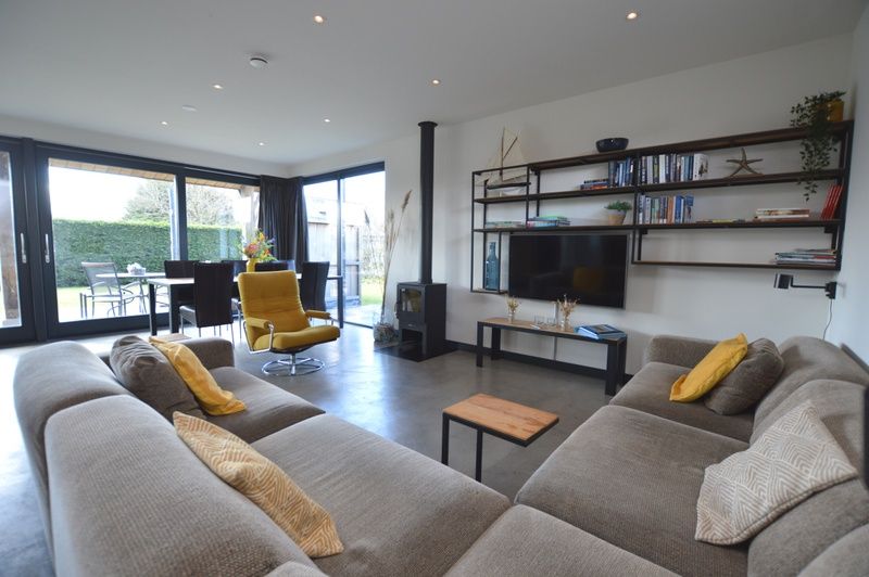 Lichte woonkamer met grote ramen in vakantiehuis 't Hoogelandt 98 - Zeelust, De Dennen, Texel.