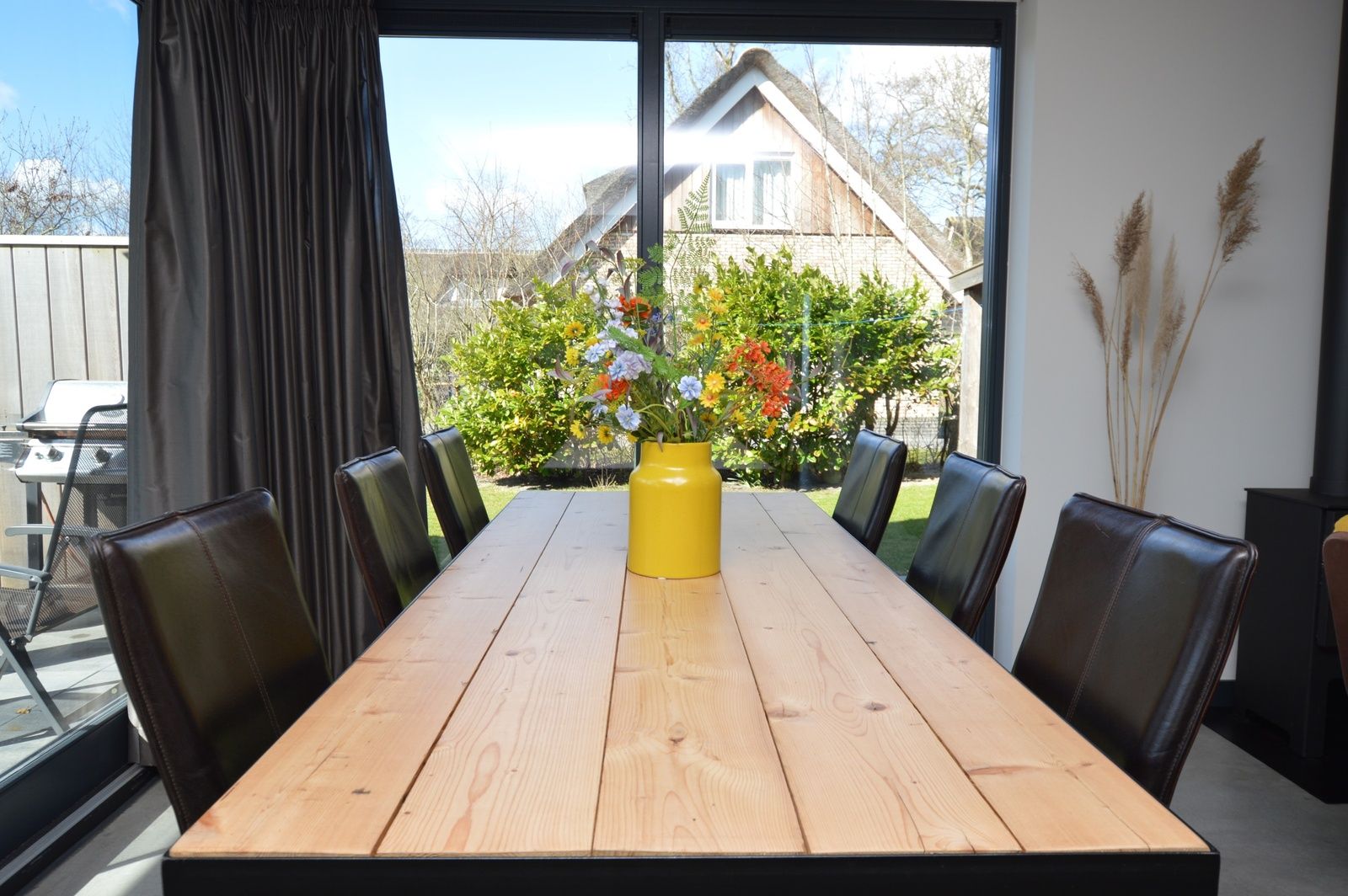 Gezellige eettafel in vakantiehuis 't Hoogelandt 98 - Zeelust, De Dennen, Texel met uitzicht op groene tuin.