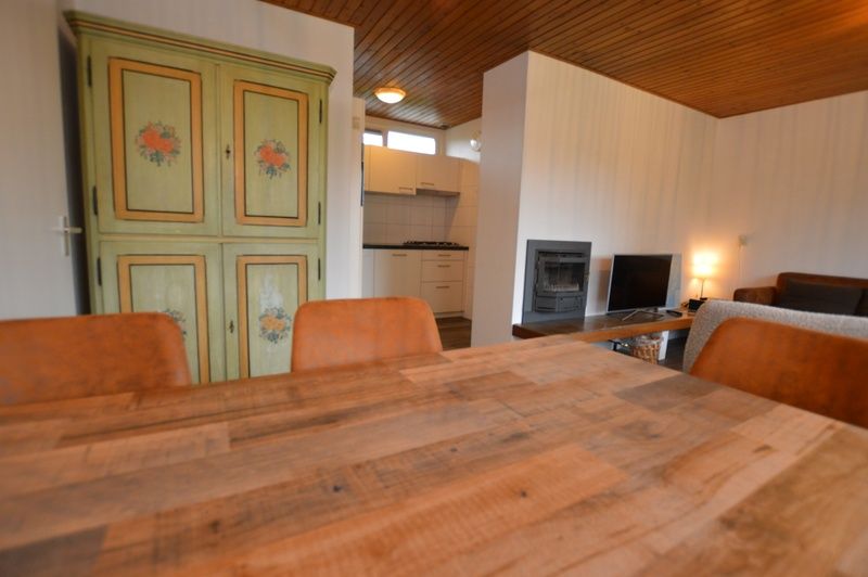 Gezellige hoek in Vakantiehuis de Parel 234, Texel met rustieke kast en open keuken.