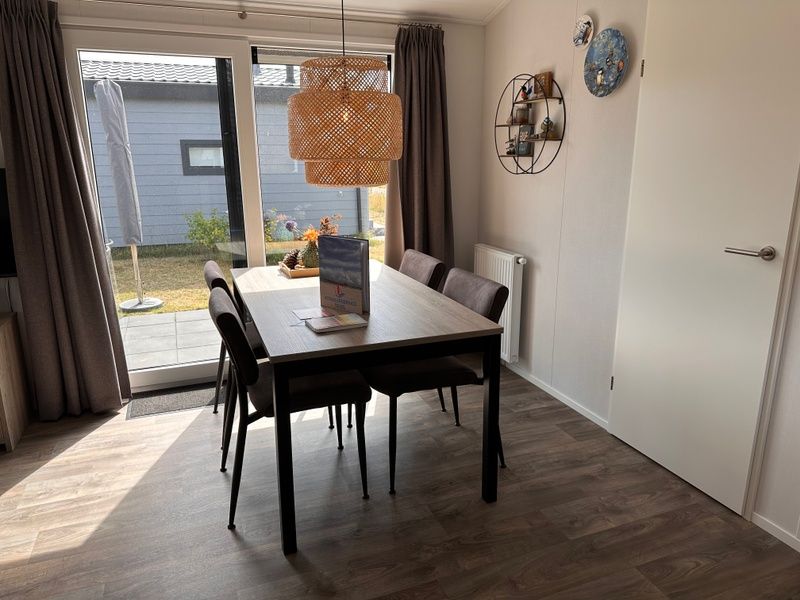 Cozy dining area in Chalet Wulk, Vakantiepark de Bremakker, Texel, overlooking the garden in De Dennen.
