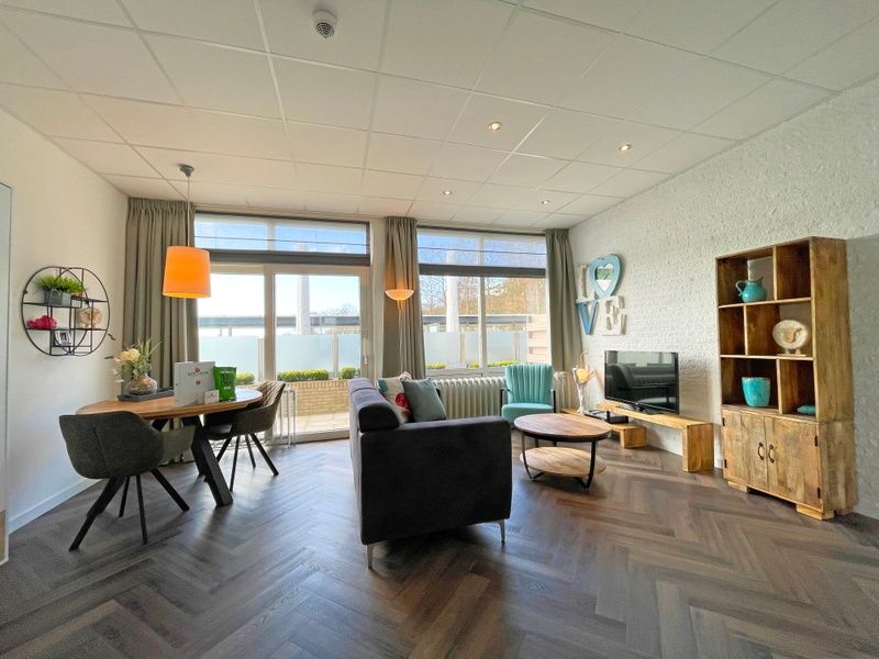 Cozy sitting area in Apartment Bos en Duin 02, De Dennen, Texel with comfortable sofas and cozy decorations.