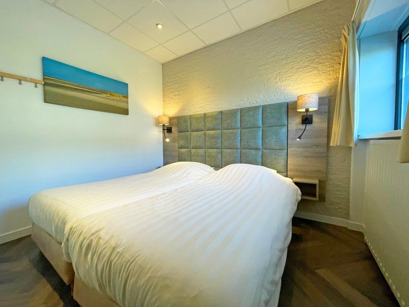 Comfortable bedroom in Apartment Bos en Duin 02, De Dennen, Texel with double bed and mood lighting.