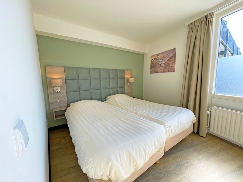 Zweites Schlafzimmer im Appartement Bos en Duin 09, De Dennen, Texel mit zwei Einzelbetten und Tageslicht.