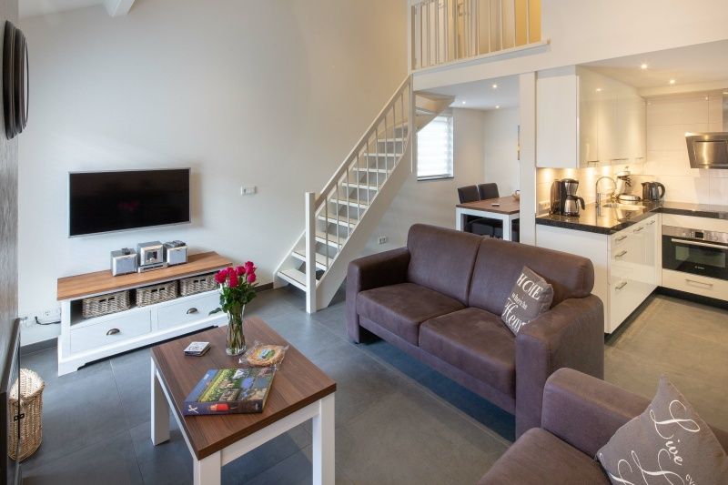 Moderne zithoek met open keuken in vakantiehuis Gortersmient 224, Bungalowpark Gortersmient, De Dennen, Texel. Comfort op de Waddeneilanden.