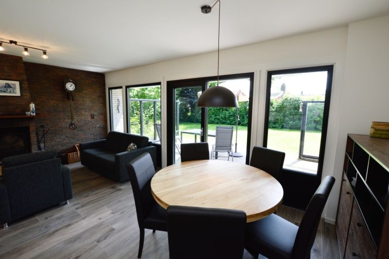 Eethoek in Tempelierweg 17 vakantiehuis, De Dennen, Texel, met tuinzicht en comfortabel meubilair.