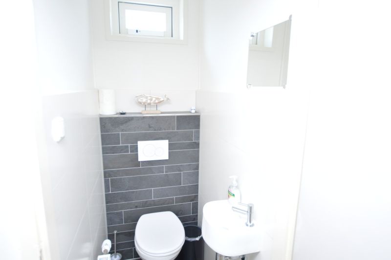 Net toilet in Tempelierweg 17 vakantiehuis, De Dennen, Texel, met strakke afwerking.