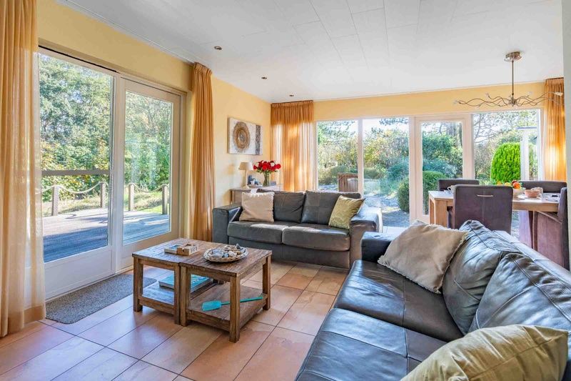 Bright living room of Landhuis Tempelierweg 22 in De Dennen, Texel, with large windows.