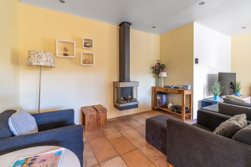 Cozy sitting area with fireplace in Landhuis Tempelierweg 22, Texel.