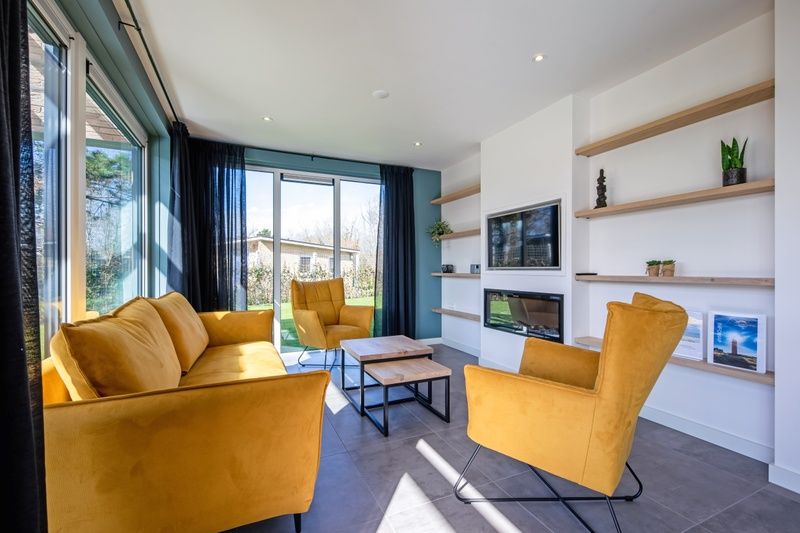 Binnenruimte van Bungalowpark 't Luwe Land - Nieuw Vredelust, De Dennen, Texel. Comfortabele zithoek met veel natuurlijk licht.