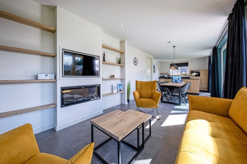 Gezellige woonkamer van Bungalowpark 't Luwe Land - Nieuw Vredelust, Texel. Moderne inrichting met open keuken en eetruimte.