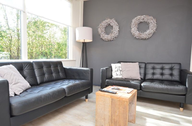 Essecke im Bungalow 't Hoogelandt 24, De Dennen, Texel mit Holztisch und bequemen Sitzgelegenheiten fuer die Familie.