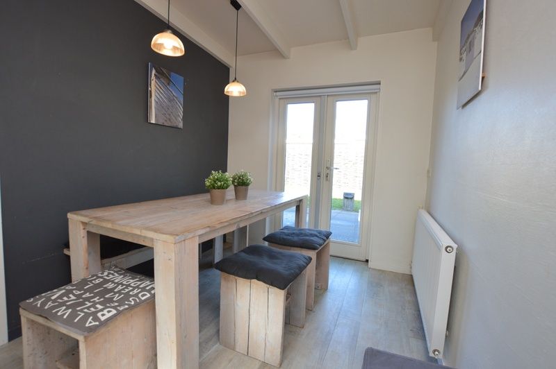 Helles und geraeumiges Wohnzimmer im Bungalow 't Hoogelandt 24, Texel, mit bequemen Sitzgelegenheiten und moderner Einrichtung.