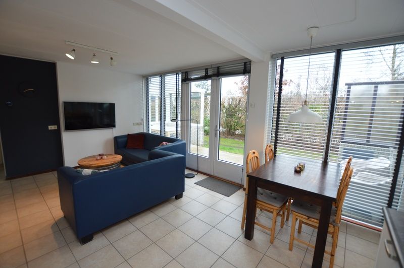 Gemuetliches Wohnzimmer im Ferienhaus de Parel 244, De Dennen, Texel mit Blick auf den Garten, ideal fuer Entspannung auf den Watteninseln.