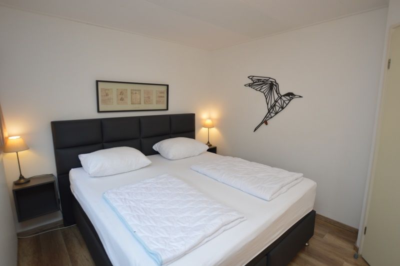 Schlafzimmer im Ferienhaus de Parel 244, De Dennen, Texel mit bequemem Bett, ideal fuer Erholung auf den Watteninseln.