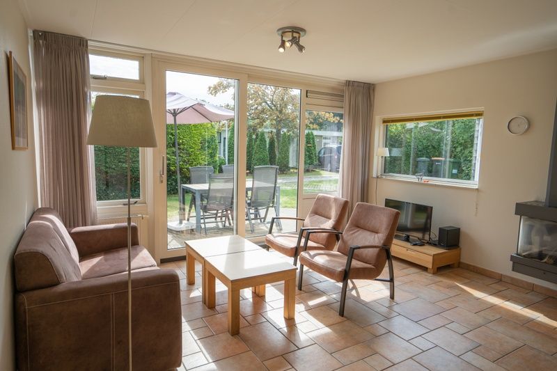 Sunny living room of Bungalow Uterste Coogh 98 in De Dennen, Texel overlooking the garden.
