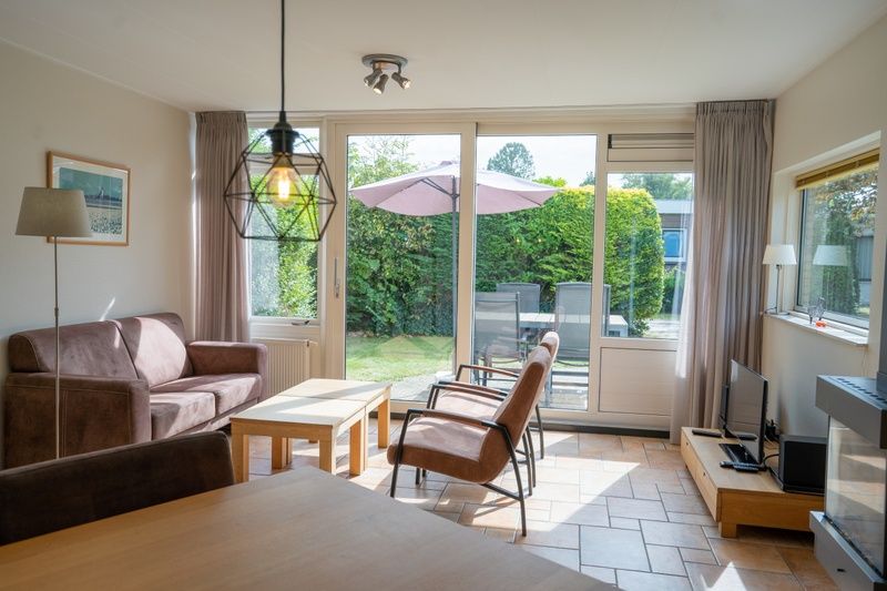 Cozy sitting area in Bungalow Uterste Coogh 98, De Dennen, Texel with access to the terrace.