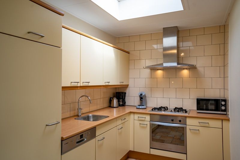Fully equipped kitchen in Bungalow Uterste Coogh 98, De Dennen, Texel with modern amenities.
