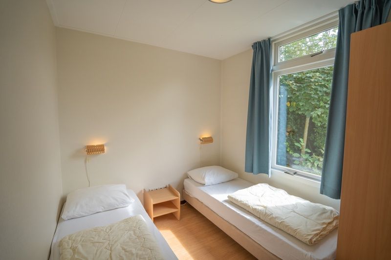 Bedroom with two single beds in Bungalow Uterste Coogh 98, De Dennen, Texel for a good night's sleep.