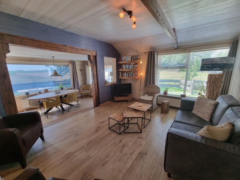 Spacious living room of Weidezicht vacation home in De Dennen, Texel with lots of light.