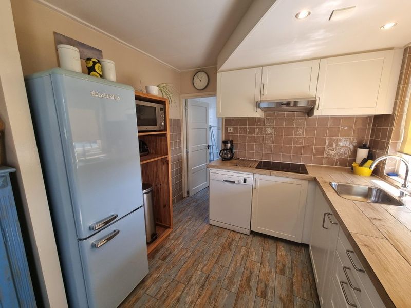 Modern kitchen of Weidezicht vacation home in De Dennen, Texel with retro fridge.
