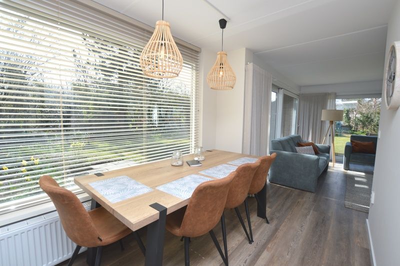 Spacious dining room in Bungalow Verste Coogh 58, De Dennen, Texel with a view of nature.