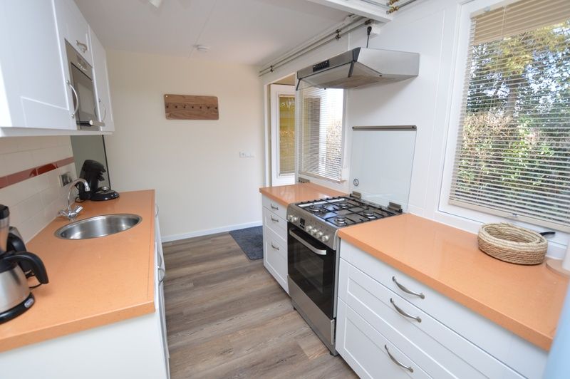 Compact kitchen in Bungalow Verste Coogh 58, De Dennen, Texel with gas stove and work space.