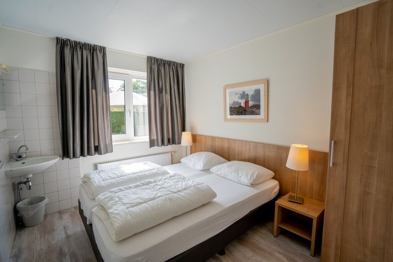 Gemuetliches Schlafzimmer im Ferienhaus 't Hoogelandt 136, De Dennen, Texel, mit grossem Fenster und natuerlichem Licht.