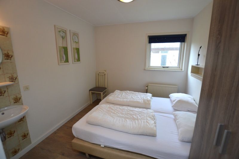 Modern bathroom in Holiday home de Parel 196, De Dennen, Texel with bath and shower.