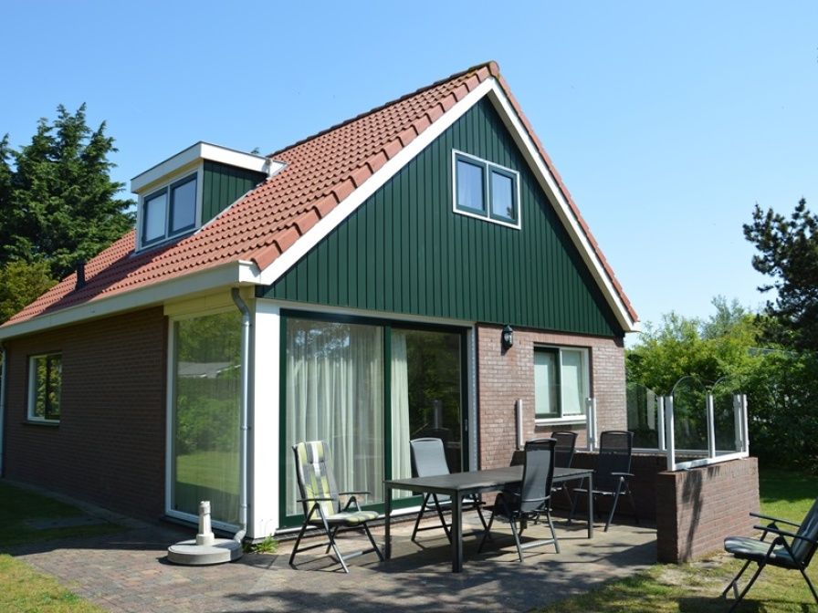 Ferienhaus 't Hoogelandt 36 in De Dennen, Texel mit sonniger Terrasse und gruener Umgebung.