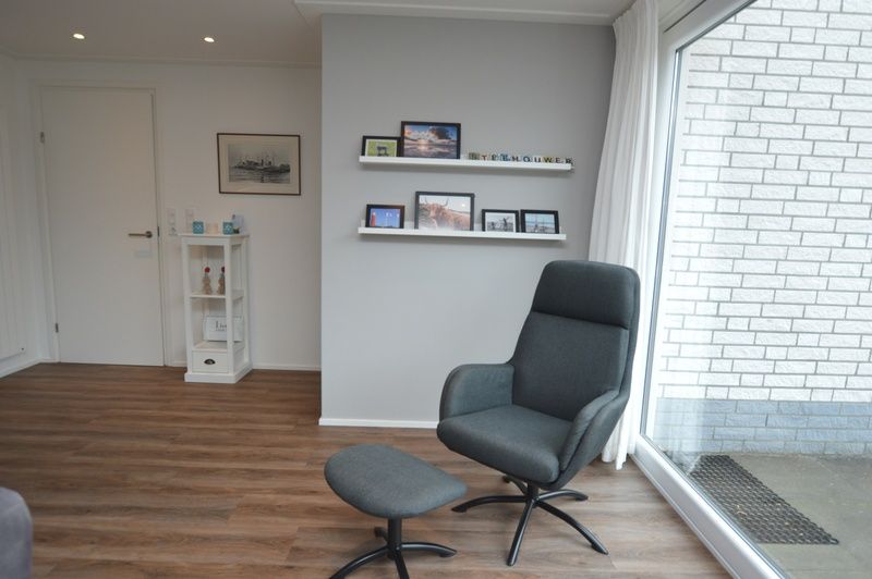 Stijlvolle leeshoek in Vakantiehuis de Parel 168, De Dennen, Texel met uitzicht op de natuur.