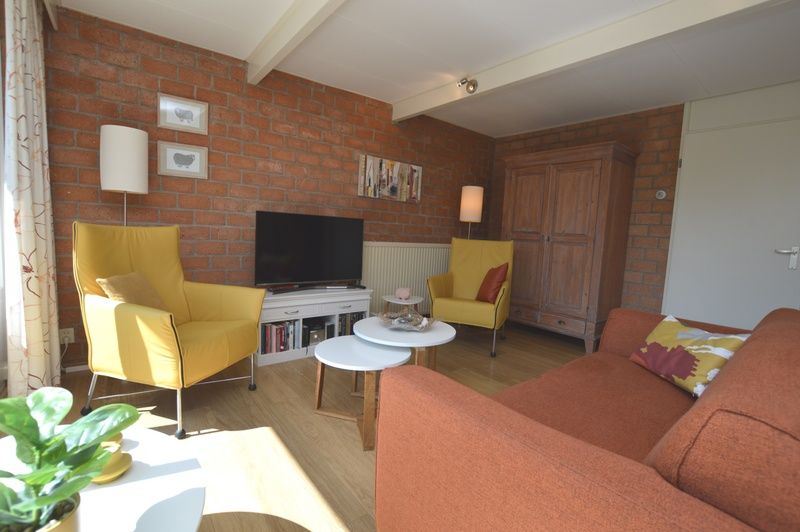 Esszimmer im Bungalow Verste Coogh 64, De Dennen, Texel mit Holztisch und stilvollen Stuehlen.