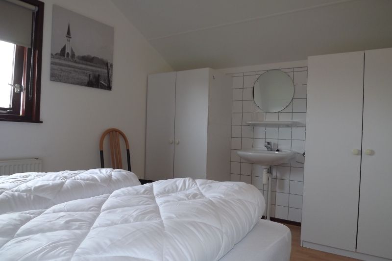 Schlafzimmer mit Waschbecken im Ferienhaus Gortersmient 234, De Dennen, Texel fuer zusaetzlichen Komfort.