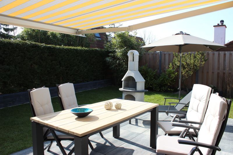 Gezellig terras met zonnescherm bij Vakantiehuis Gortersmient 256 in De Dennen, Texel.