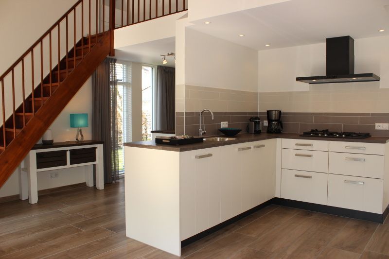 Moderne keuken in Vakantiehuis Gortersmient 256, De Dennen, Texel met open trap.