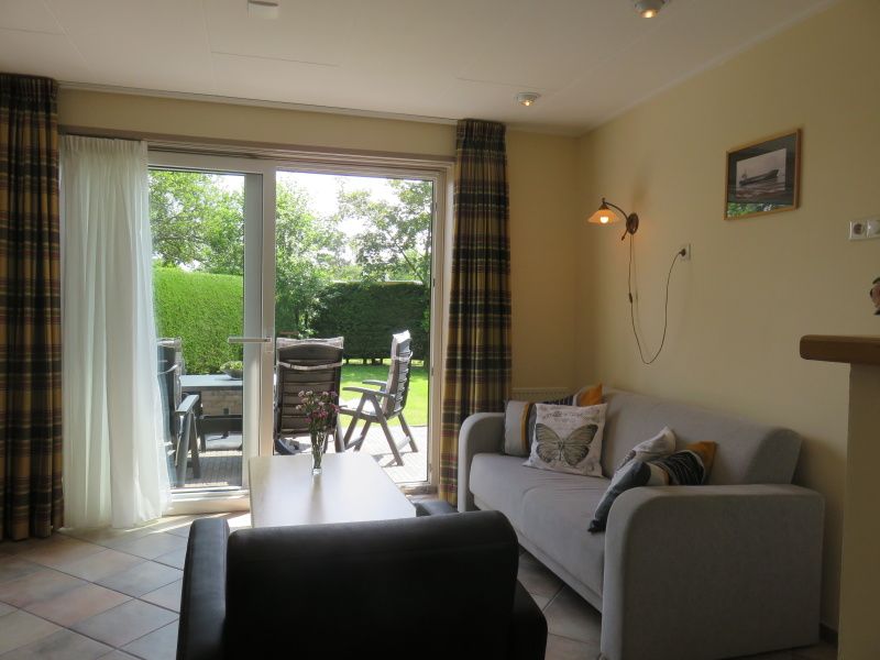 Gemuetliches Wohnzimmer im Bungalowpark Uterste Coogh, Bungalow 114 in De Dennen, Texel, mit Blick auf den Garten.