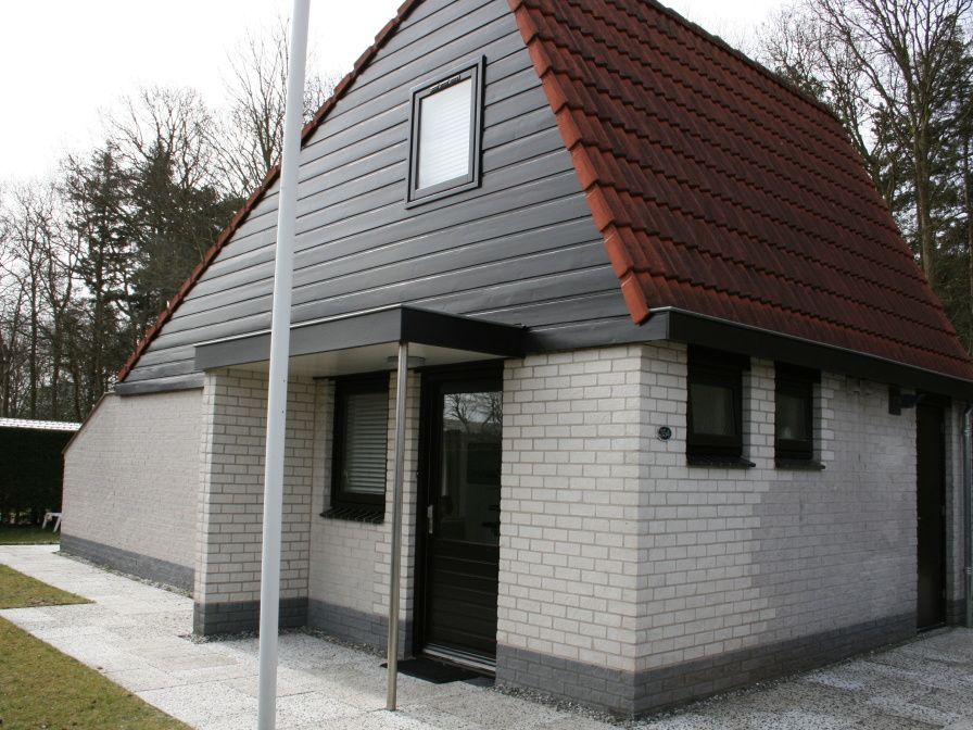 Ferienhaus Gortersmient 354 in De Dennen Texel mit traditioneller Fassade und roten Dachziegeln.