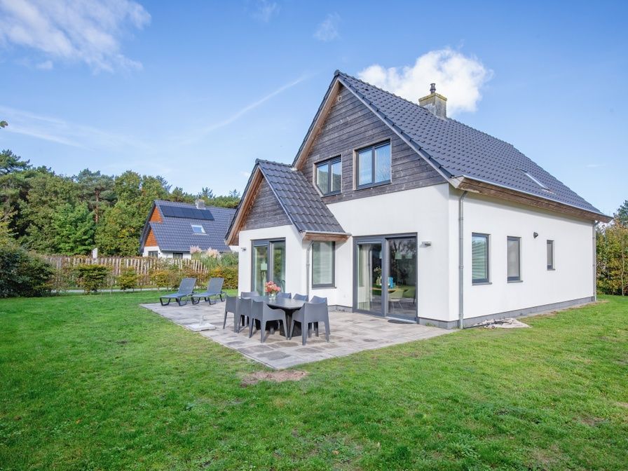Bungalowpark 't Hoogelandt - Villa Bloem en Bos in De Dennen, Texel bietet ein geraeumiges Ferienhaus mit einer schoenen Terrasse und einem gruenen Garten.