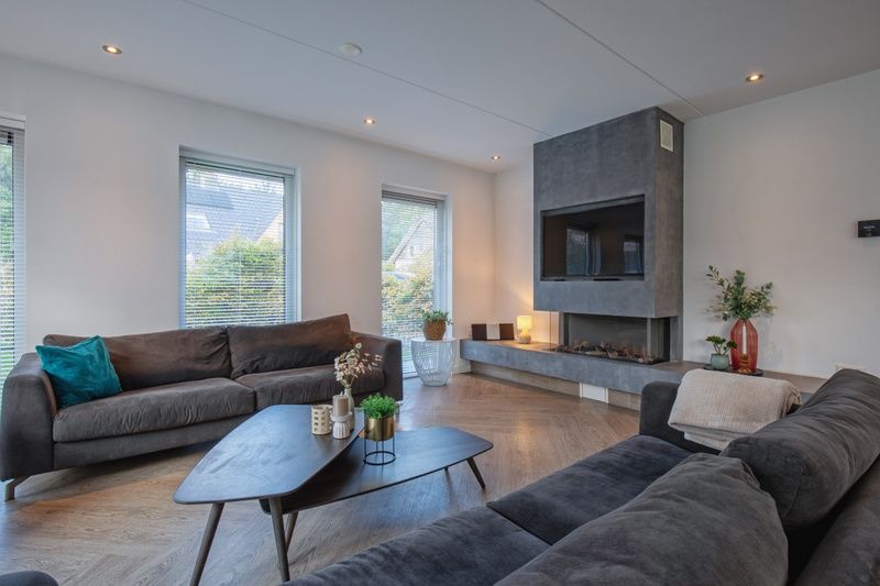 Gemuetliche Sitzecke mit Kamin in der Villa Bloem en Bos, De Dennen, Texel, ideal fuer entspannte Abende.