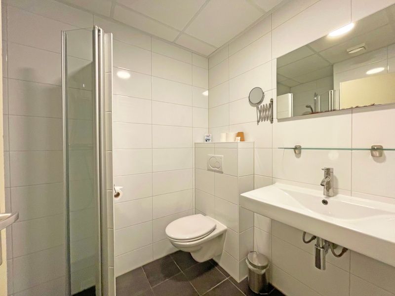 Strakke badkamer in Appartement Bos en Duin 05, De Dennen, Texel met douche, toilet en wastafel.