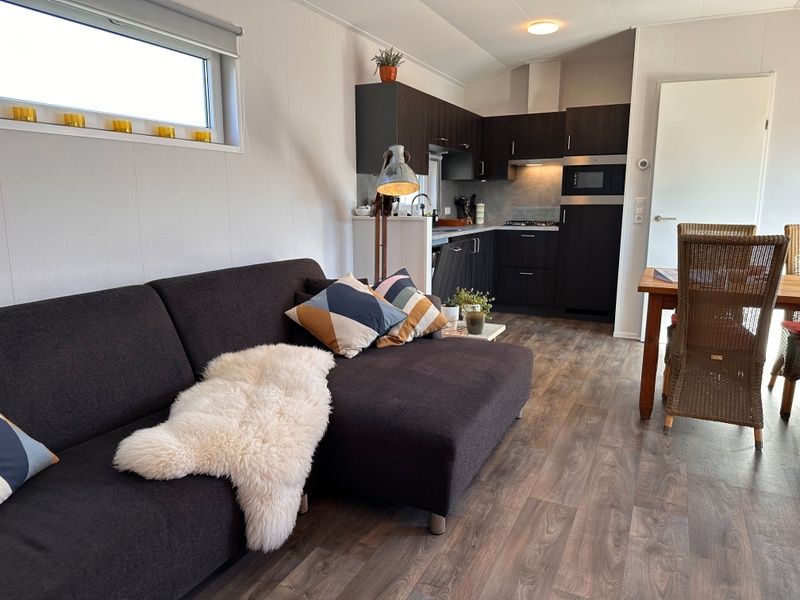 Vakantiepark de Bremakker - Bosveld 141, Texel, open kitchen and living room with comfortable sofa and dining area.